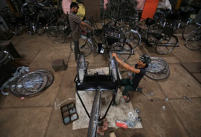Workers assemble tricycles inside a manufacturing unit in Ahmedabad, India, August 30, 2018. (Photo by Amit Dave/Reuters)