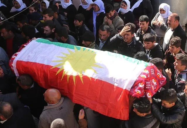 Members of the Peshmerga and relatives of a Peshmerga fighter killed in a suicide attack in Sinjar province, mourn before the body is taken for a burial ceremony at Mazar Sharaf Eldin, a sacred and a cemetery area for the Yazidi minority, north of Sinjar, March 2, 2015. A number of Peshmerga were killed and others injured after two suicide car bombs attacks targeted a building the Peshmerga were using for fighting, according to Peshmerga officials. REUTERS/Asmaa Waguih 