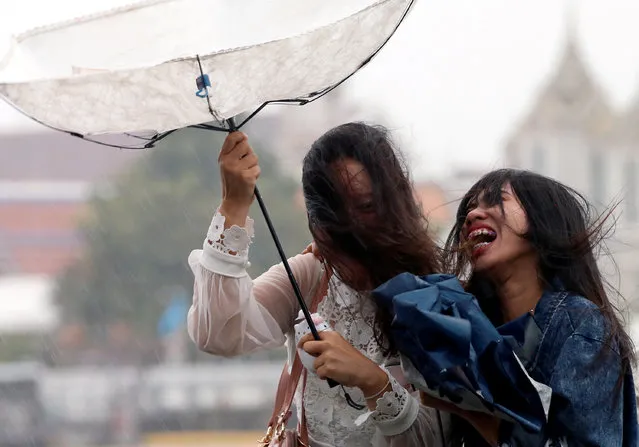 Women use an umbrella during heavy rain fall in Bangkok, Thailand on August 19, 2018. (Photo by Soe Zeya Tun/Reuters)