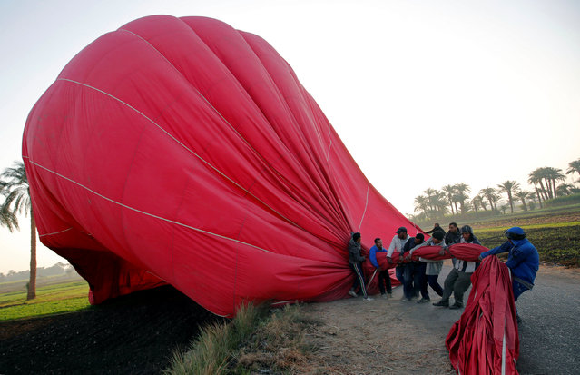 Crew members work to secure a hot-air balloon after landing at the city of Luxor, south of Cairo, Egypt December 13, 2016. (Photo by Amr Abdallah Dalsh/Reuters)
