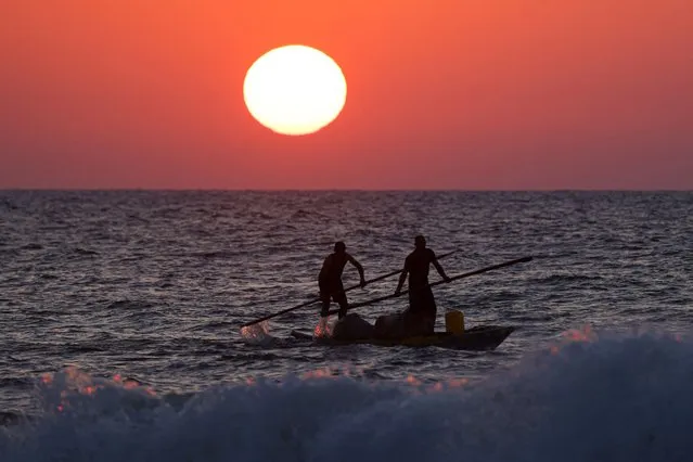 Palestinian fishermen return to the coastline in their kayaks during sunset in Gaza City, on September 5, 2023. (Photo by Mahmud Hams/AFP Photo)