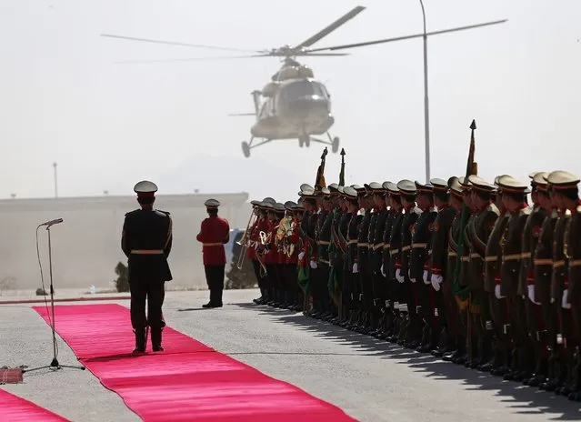 Honour guards watch as the helicopter of Afghanistan's President Ashraf Ghani lands, before a graduation ceremony at the National Military Academy in Kabul, March 18, 2015. (Photo by Omar Sobhani/Reuters)