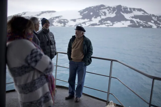 In this January 27, 2015 photo, tourists stand on The Aquiles, a Chilean Navy icebreaker, near Bahia Almirantazgo, Livingston Island, South Shetland Island archipelago, Antarctica. Although many tourists are nature-loving retirees who mostly stay aboard cruise ships, conservationists worry about potentially devastating environmental damage from boat pollution and from the more adventurous visitors who hike or cross-country ski around sensitive sites. (Photo by Natacha Pisarenko/AP Photo)