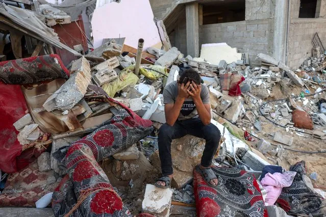 A Palestinian youth reacts as he sits on the rubble of a destroyed home following an Israeli military strike on the Rafah refugee camp, in the southern of Gaza Strip on Octobers 15, 2023, amid the ongoing battles between Israel and the Palestinian Islamist group Hamas. Thousands of people, both Israeli and Palestinians have died since October 7, 2023, after Palestinian Hamas militants based in the Gaza Strip, entered southern Israel in a surprise attack leading Israel to declare war on Hamas in Gaza on October 8. (Photo by Mohammed Abed/AFP Photo)