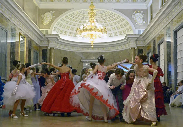 Participants dance during a Christmas ball in Saint Petersburg, on December 27, 2016. Cadets of the Naval Academy and of the Suvorov Military School and students of Academy of Vaganova Academy of Russian Ballet gathered for their first ball in the Saint George Hall of the Mikhailovsky Castle, restoring the old tradition of Russian officers and noble maidens. (Photo by Olga Maltseva/AFP Photo)