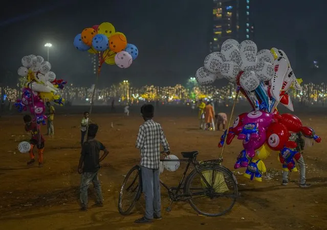 A group of balloon sellers wait for customers at the park during Diwali, the Hindu festival of lights, in Mumbai, India, Sunday, November 12, 2023. (Photo by Rafiq Maqbool/AP Photo)
