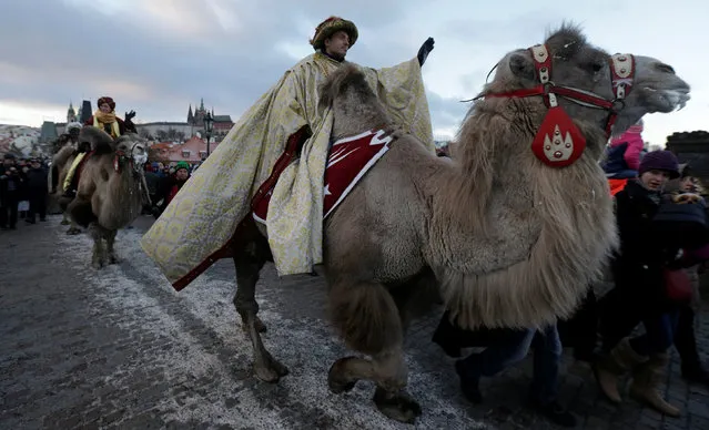 Men dressed as the Three Kings greet spectators as they ride camels during the Three Kings procession across the medieval Charles bridge, as a part of a re-enactment of the Nativity scene, in Prague, Czech Republic January 6, 2017. (Photo by David W. Cerny/Reuters)