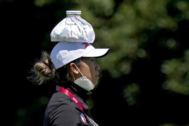 Bianca Pagdanganan, of the Philippines, wears an ice pack on her head to keep cool during a practice round prior to the women's golf event at the 2020 Summer Olympics, Tuesday, August 3, 2021, at the Kasumigaseki Country Club in Kawagoe, Japan. (Photo by Matt York/AP Photo)