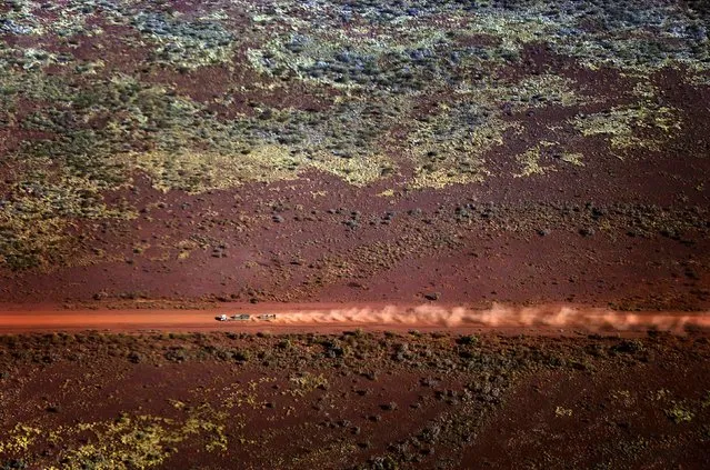 A truck drives along a dirt road in the Pilbara region of Western Australia December 3, 2013. Western Australia's Pilbara region, which is the size of Spain, has the world's largest known deposits of iron ore and supplies nearly 45 percent of global trade in the mineral. (Photo by David Gray/Reuters)