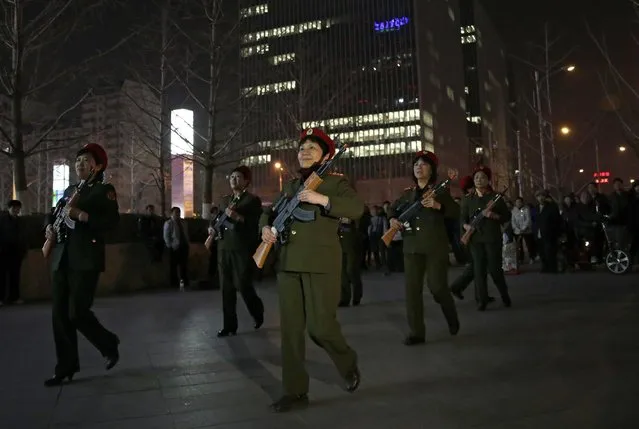 In this Tuesday, March 24, 2015 photo, Chinese women holding toy guns march to a revolutionary song during their daily exercises at a square outside a shopping mall in Beijing. The group is a part of senior health trend that has filled squares and apartment courtyards across China, winning the admiration of medical experts but upsetting neighbors over the noise level. (Photo by Andy Wong/AP Photo)