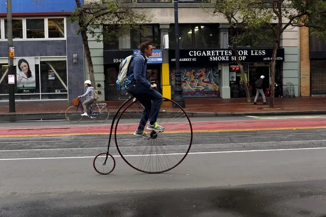 A man rides a penny-farthing bicycle along Market Street in San Francisco, California April 7, 2015. (Photo by Robert Galbraith/Reuters)