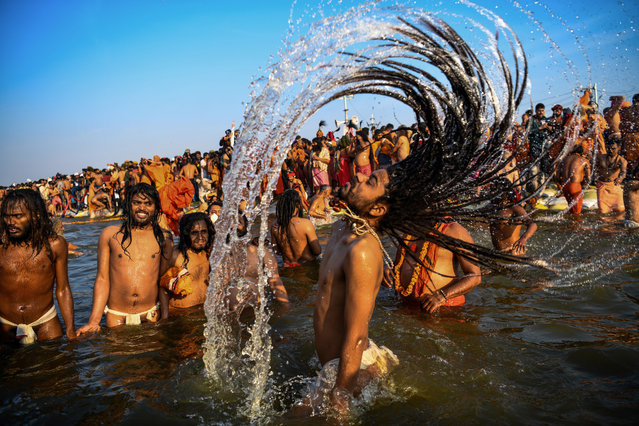 Indian sadhus (Hindu holy men) take a dip into the water of the holy Sangam – the confluence of the Ganges, Yamuna and mythical Saraswati rivers – during the auspicious bathing day of Makar Sankranti at the Kumbh Mela in Allahabad, on January 15, 2019. State authorities in Uttar Pradesh are expecting 12 million visitors to descend on Allahabad for the centuries-old festival, which officially begins on January 15 and continues until early March. (Photo by Chandan Khanna/AFP Photo)