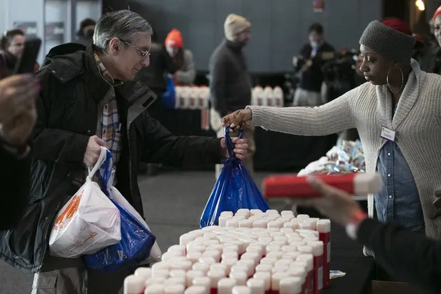 A government worker, left, gets groceries at a food bank for government workers affected by the shutdown, Tuesday, January 22, 2019, in the Brooklyn borough of New York. (Photo by Mark Lennihan/AP Photo)