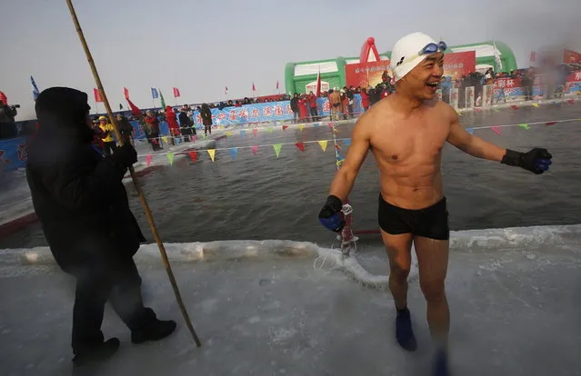 A swimmer reacts after swimming in a pool carved into the thick ice covering the Songhua River during the Harbin Ice Swimming Competition in the northern city of Harbin, Heilongjiang province January 5, 2014. (Photo by Kim Kyung-Hoon/Reuters)