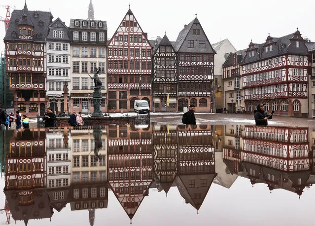 The timber-frame houses at the Roemerberg square are reflected in water in Frankfurt, central Germany, Wednesday, January 11, 2017. (Photo by Michael Probst/AP Photo)