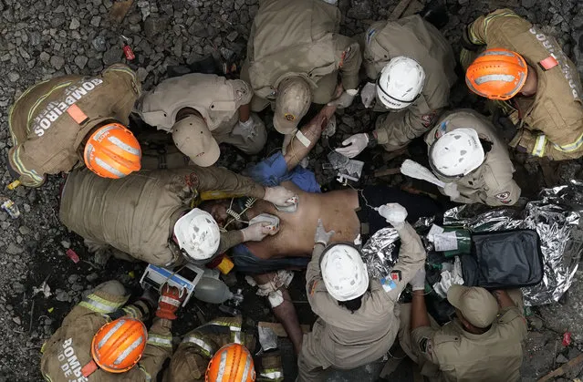 Firefighters work to resuscitate the driver of a commuter train that was involved in a collision with another train in Sao Cristovao station, in Rio de Janeiro, Brazil, Wednesday, February 27, 2019. Firefighters worked for over six hours to rescue the train's driver, who was caught under the wreckage. (Photo by Leo Correa/AP Photo)