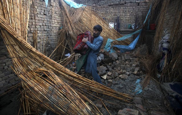 A man collects belongings from his house partially-destroyed following heavy rain in the outskirts of Peshawar, Pakistan, April 27, 2015. (Photo by Fayaz Aziz/Reuters)
