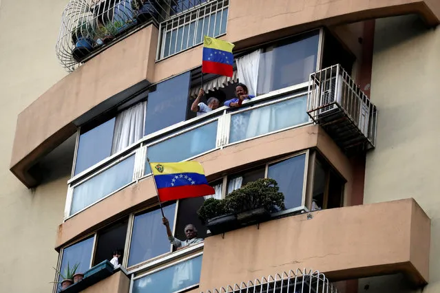 People wave the national flag from their windows during a protest against President Nicolas Maduro's government in Caracas, Venezuela, March 12, 2019. (Photo by Carlos Garcia Rawlins/Reuters)