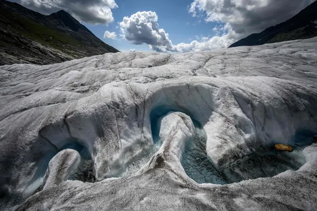 A picture taken on August 25, 2021 shows a view of the Aletsch Glacier. After hiking for hours across the mountain and a vast expanse of white, Swiss glaciologist Matthias Huss crouches down near the middle of the massive glacier and checks the measurements. Analysis of the data gathered from Aletsch, the largest glacier in the Alps, paints a dire picture of the toll that climate change is taking on the behemoth. (Photo by Fabrice Coffrini/AFP Photo)