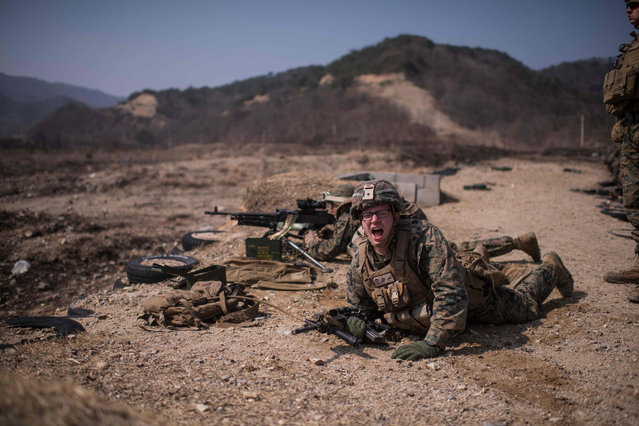 In a photo taken on March 15, 2016 US soldiers of the 31st Marine Expeditionary Unit infantry take part in a live fire drill during an exercise entitled “Ssang Yong”, near South Korea's southeastern port city of Pohang. Ssang Yong, meaning “twin dragons”, is a biennial military exercise “focused on strengthening the amphibious landing capabilities of the U.S. and its allies”, according to the US Pacific Command. The 11-day exercise brings together US Marines of the 13th and 31st Marine Expeditionary Units and their South Korean counterparts. (Photo by Ed Jones/AFP Photo)