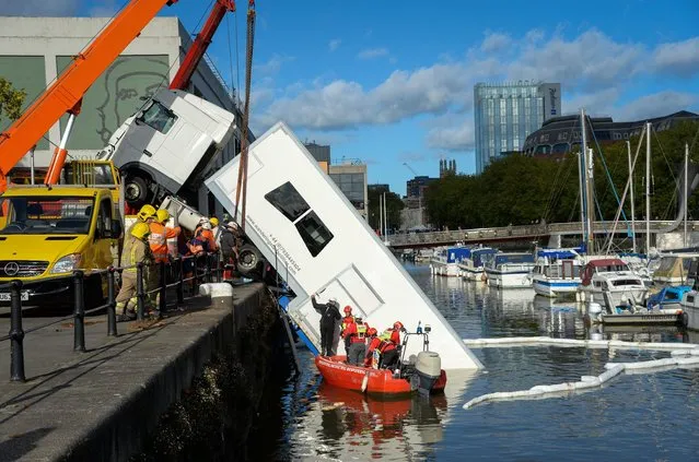 A HGV lorry is recovered from the harbour on October 21, 2021 in Bristol, England. Emergency services were called after a lorry reversed into the harbour in Bristol's City Centre with the cab remaining on the dock. (Photo by Finnbarr Webster/Getty Images)
