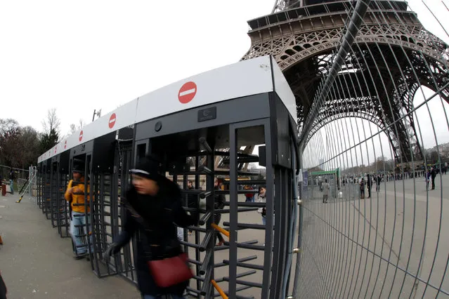 Visitors leaves the Eiffel tower through gates surrounded by fences in Paris, France, February 10, 2017. The Eiffel Tower, one of the world's most famous landmarks, will get a glass wall built round its base under a plan to provide extra protection against attacks, a source in the Paris mayor's office said. (Photo by Philippe Wojazer/Reuters)