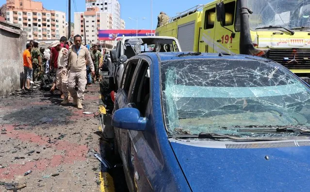 Security personnel prepare to remove a vehicle at the site of a deadly car bomb attack that targeted two senior government officials, who survived, security officials said, in the port city of Aden, Yemen, Sunday, October 10, 2021. Aden has been the seat of the internationally recognized government of President Abed Rabbo Mansour Hadi since the Iranian-backed Houthi rebels took over the capital, Sanaa, triggering Yemen’s civil war. (Photo by Wael Qubady/AP Photo)