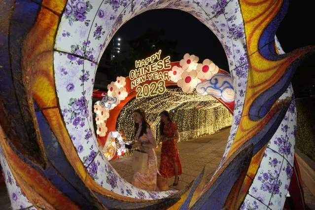 Women walk through decorations for the upcoming Chinese Lunar New Year in Bangkok, Thailand, Thursday, January 19, 2023. Chinese New Year falls on Jan. 22 this year, marking the start of the Year of Rabbit, according to the Chinese lunar calendar. (Photo by Sakchai Lalit/AP Photo)