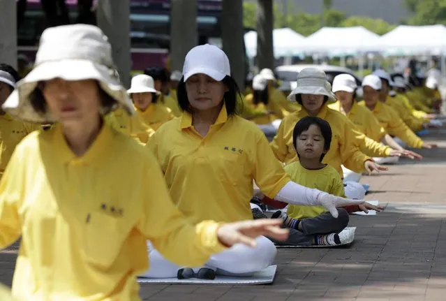 South Korean members of Falun Dafa, also known as Falun Gong, perform during a rally to commemorate “World Falun Dafa Day”, which falls on May 13, in Seoul, South Korea, Sunday, May 10, 2015. More than 500 practitioners attending Sunday's rally denounced the Chinese government's alleged policy of harassment and torture of Falun Dafa members in China. (Photo by Ahn Young-oon/AP Photo)