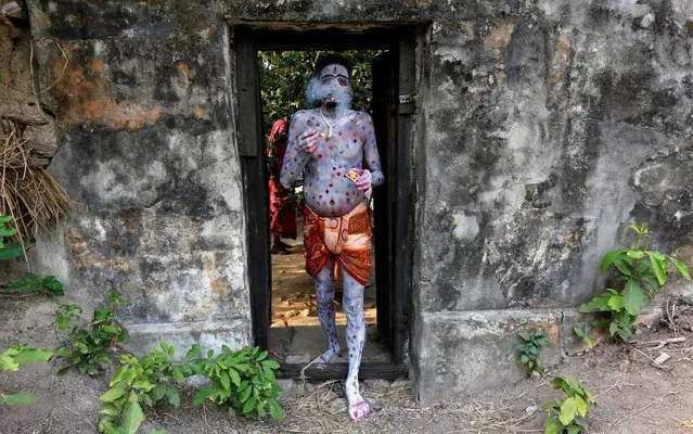 A devotee with his body painted smokes as he arrives to perform during a ritual as part of the annual Shiva Gajan religious festival at Sona Palasi village, in West Bengal, India, April 11, 2016. (Photo by Rupak De Chowdhuri/Reuters)