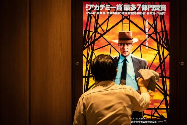 A worker cleans a screen showing a poster for the film “Oppenheimer” in Tokyo on March 29, 2024. Oscars best picture winner “Oppenheimer” was finally released on March 29 in Japan, where its subject – the man who masterminded the atomic bomb – is a highly sensitive and emotional topic. (Photo by Yuichi Yamazaki/AFP Photo)