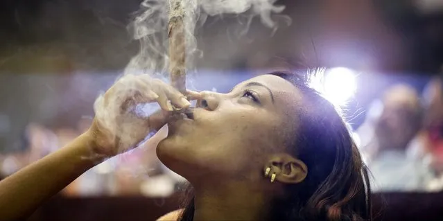 A woman smokes a Montecristo cigar during a cigar smoker's competition for the longest ash, during the 17th Habanos tobacco festival, on February 26, 2015 in Havana, Cuba. The festival is held every year and will culminate in a gala dinner with an auction of humidors on Friday. After the latest developments in the relationships between Cuba and the Uniteed States, Americans are now allowed to import Cuban cigars up to $100 USD. The second round of talks about re-establishing diplomatic relations between both governments will take place on February 27 in Washington. (Photo by Sven Creutzmann/Mambo Photo/Getty Images)