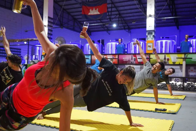 People participate in a beer yoga session, as the country eases the coronavirus disease (COVID-19) restrictions, at a craft brewery in Phnom Penh, Cambodia on January 19, 2021. (Photo by Cindy Liu/Reuters)