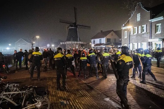 Dutch riot policemen intervene to end an illegal party in Dalfsen, the Netherlands, 16 January 2022. Police intervened to end the illegal party in front of the town hall in the Overijssel village of Dalfsen after mayor Erica van Lente issued an emergency order to call riot squad to break up the party. (Photo by Roland Heitink/EPA/EFE)
