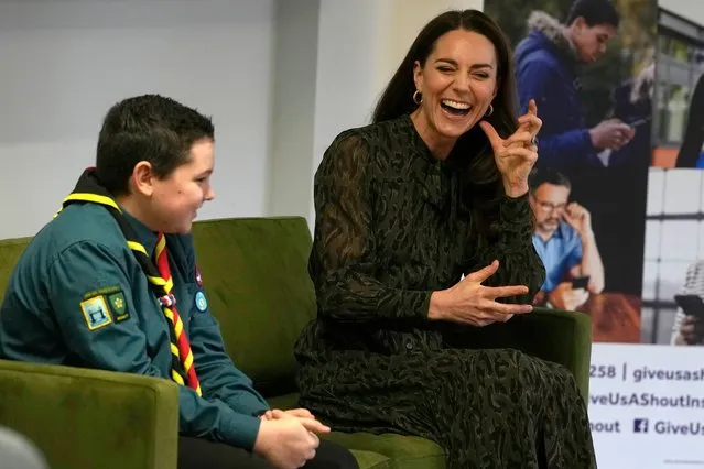 Britain's Catherine, Duchess of Cambridge, sits beside scout Leo Street during her visit to the charity Shout, to mark the mental health text service reaching over one million conversations with those in need, in London, on January 26, 2022. The Duchess will meet clinical supervisors, volunteers and fundraisers to thank them for their invaluable efforts to ensure that vital mental health support is available across the UK at any time of day or night. (Photo by Alastair Grant/Pool via AFP Photo)