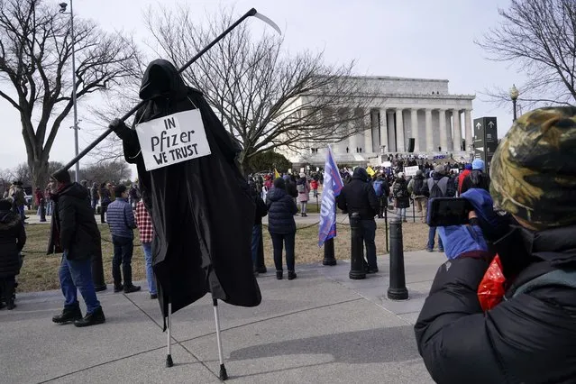 A protester dressed as the Grim Reaper participates in an anti-vaccine rally in front of the Lincoln Memorial in Washington, Sunday, January 23, 2022. (Photo by Patrick Semansky/AP Photo)
