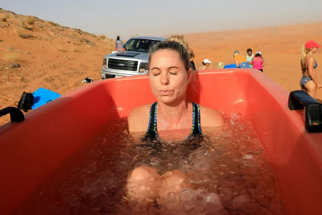 A participant sits in an ice bucket during an ice bath therapy session at the desert near Sharjah, United Arab Emirates, June 25, 2021. (Photo by Rula Rouhana/Reuters)
