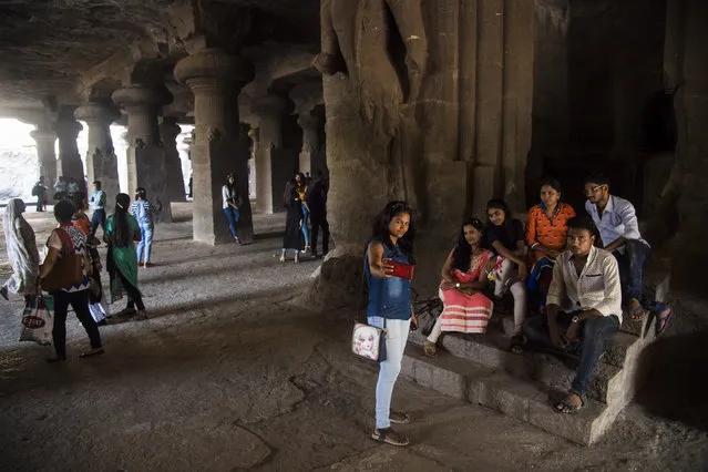 People walk around, take photos, make phone calls, and admire the large carvings in the Elephanta Caves, a UNESCO World Heritage Centre and contain a collection of rock art linked to the cult of Shiva, on Elephanta Island in Navi Mumbai, India on Tuesday May 10, 2016. (Photo by Jabin Botsford/The Washington Post)
