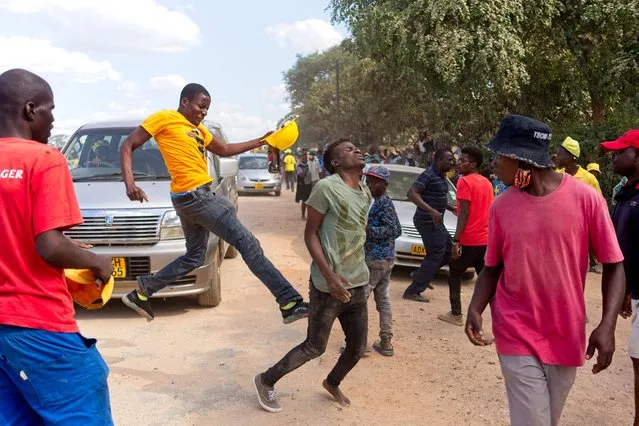 A man, suspected of being a ruling ZANU-PF attacker reacts after being kicked by a supporter of the opposition Citizens Coalition for Change during an electoral rally on February 27, 2022 at Mbizo shopping centre in Kwekwe. At least 17 Zimbabwean opposition activists were hospitalized on Sunday, and another killed, during violence that broke out on the sidelines of a rally in Kwekwe (center), we learned from the Coalition of Citizens for change (CCC). Thousands of activists had gathered to listen to a speech by Nelson Chamisa, party leader and main opponent of President Emmerson Mnangagwa and his ZANU-PF party, in power since independence (Photo by Zinyange Auntony/AFP Photo)