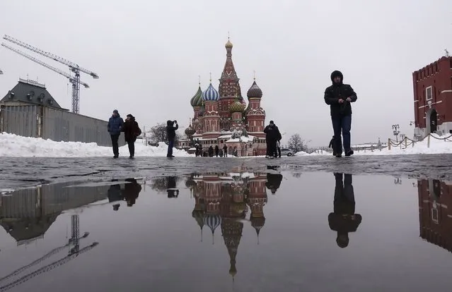 St. Basil's Cathedral is reflected in a puddle as people walk in Red Square in central Moscow, Russia, March 2, 2016. (Photo by Maxim Zmeyev/Reuters)