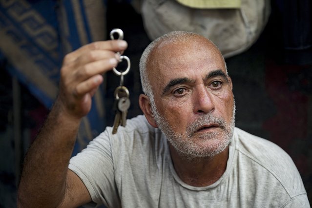 Hassan Nofal, 53, who was displaced by the Israeli bombardment of the Gaza Strip, holds the keys to his home that he was forced to leave with his family at a makeshift tent camp in Khan Younis, southern Gaza Strip, Thursday, July 4, 2024. Over nine months of war between Israel and Hamas, Palestinian families in Gaza have been uprooted repeatedly, driven back and forth across the territory to escape the fighting. Each time has meant a wrenching move to a new location and a series of crowded, temporary shelters. (Photo by Abdel Kareem Hana/AP Photo)