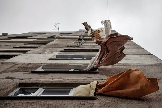 Curtains flutter in the wind at a building that was damaged by shelling in a neighbourhood that has been largely abandoned and left without water, gas and heating, as Russia's attack on Ukraine continues, in Kharkiv, Ukraine, March 28, 2022. (Photo by Thomas Peter/Reuters)