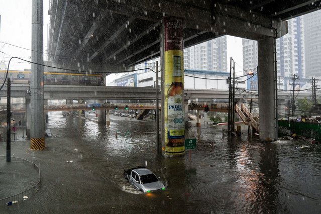 A car wades through a flooded road following heavy rains brought by Typhoon Gaemi, in Manila, Philippines, on July 24, 2024. (Photo by Lisa Marie David/Reuters)