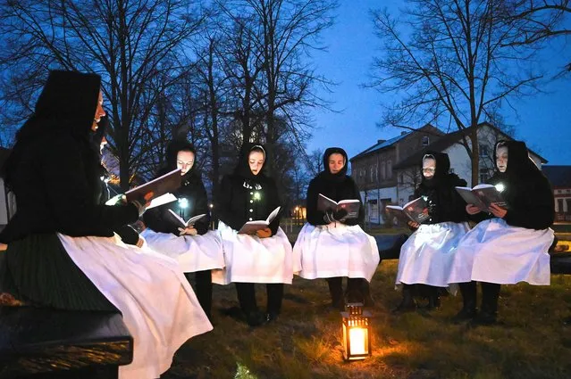 Women dressed in traditional clothes of the Slavic ethnic minority of Sorbs meet early on Easter Sunday to sing in front of a church in Schleife, eastern Germany, April 17, 2022. (Photo by Matthias Rietschel/Reuters)