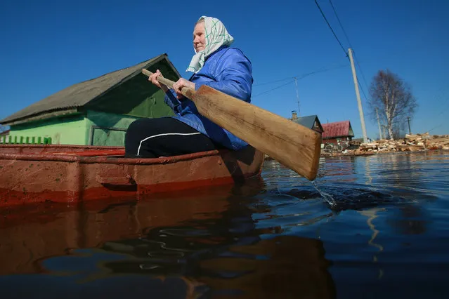 A resident of the village of Kholuy is sailing in a boat to her house in Ivanovo region, Russia on April 14, 2016. In the village of Kholuy, due to the rise in the water level in the Teza River, several household plots in private sector homes were flooded. (Photo by Vladimir Smirnov/TASS)