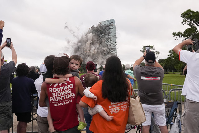 Tuff Gary, left, and Morgan LeBlanc with their children Hudson, Tuff, Jr., and Zander, of Jenning, La., watch the implosion of the Hertz Tower, that was heavily damaged after Hurricanes Laura and Delta in 2020 in Lake Charles, La., Saturday, September 7, 2024. (Photo by Gerald Herbert/AP Photo)