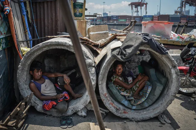 A homeless man and woman rest inside concrete drainage pipes in a slum area on April 26, 2017 in Manila, Philippines. (Photo by Ezra Acayan/Barcroft Images)