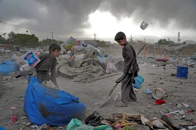 Two Afghan children collect recyclable material from a garbage dump in Kabul, Afghanistan, Sunday, May 8, 2022. (Photo by Ebrahim Noroozi/AP Photo)