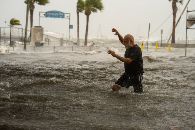 A man crosses an area flooded by the storm surge in Gulfport, Fla. on September 26, 2024, (Photo by Thomas Simonetti)