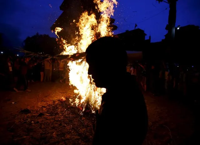 A man is silhouetted as he walks past a burning effigy of the demon Ghantakarna, during the Ghantakarna festival at the ancient city of Bhaktapur, Nepal August 12, 2015. (Photo by Navesh Chitrakar/Reuters)